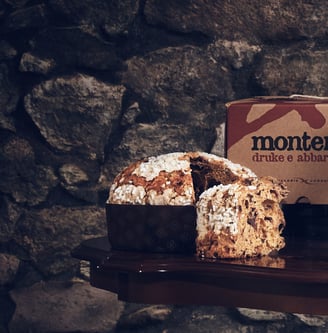 Il dolce Monterra tagliato, davanti alla sua confezione, su un muro in pietra
