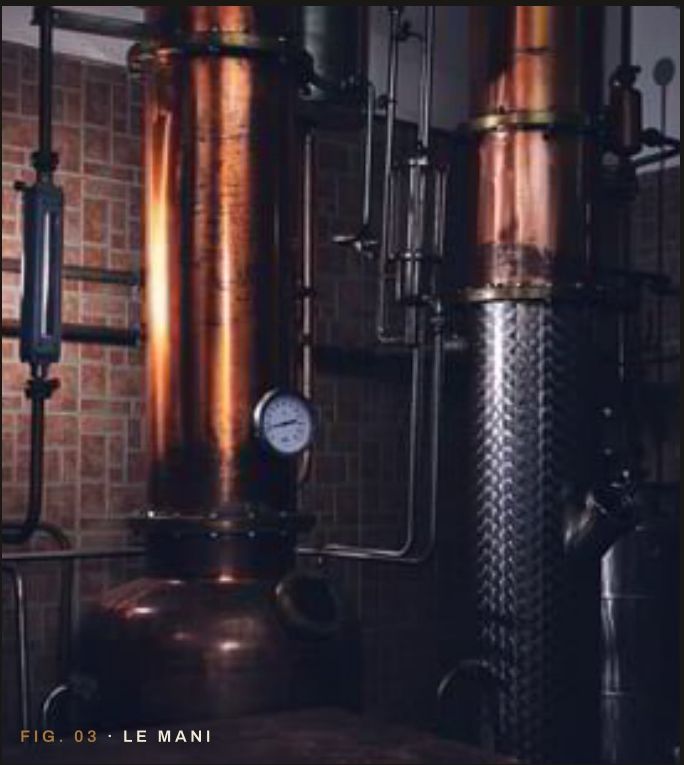 Carlo Pische degusta il distillato davanti agli alambicchi in rame